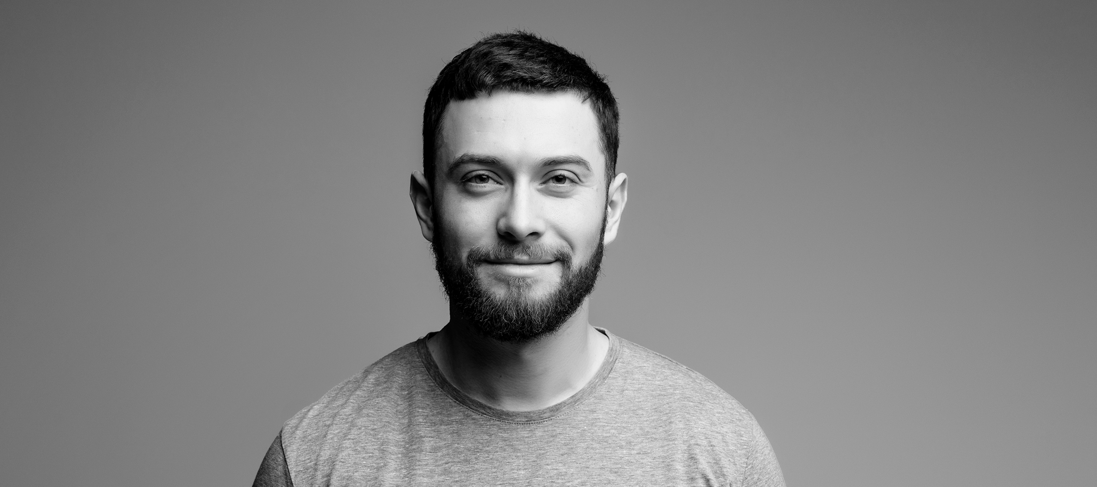 Mężczyzna patrzy w obiektyw, uśmiecha się